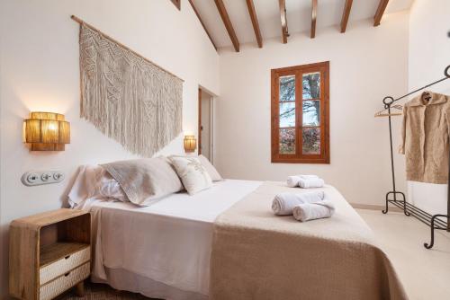 Un dormitorio con una cama grande con toallas. en E425 Can Brasa by Mallorca Villa Selection, en Alcudia