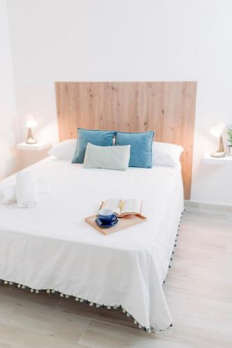 Apartamento El EnTorno في Valle de Abdalagís: غرفة نوم بسرير ابيض مكتوب عليها