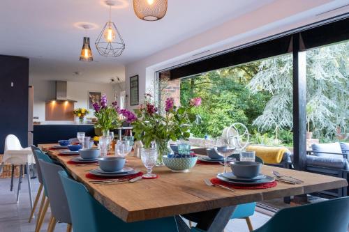 a dining room table with a large window in a kitchen at Furzedown Farm House in Hythe