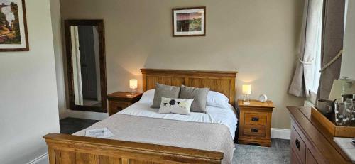 a bedroom with a bed with two night stands and two lamps at Halmer Grange Guest House in Goathland