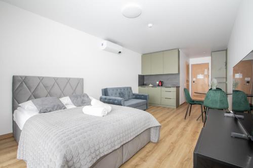 a bedroom with a bed and a living room at Studio W/Balcony @ManoŠventovė, By Cohost in Palanga