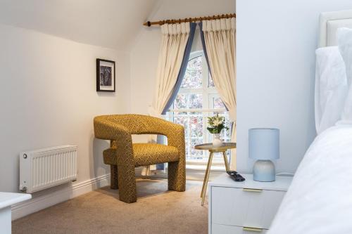 a bedroom with a chair and a window at Stylish quaint home hosted by ESONGRACE Stays in Stoke-on-Trent - Perfect for Families - Contractors - Holiday makers - Emergency Housing - Professionals in Stoke on Trent