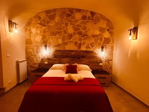 a bedroom with a large bed with a stone wall at Immota Manet in LʼAquila