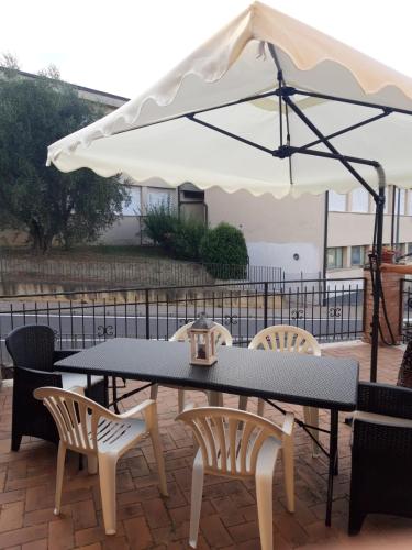 a table and chairs under an umbrella on a patio at L'Affresco in Cetona