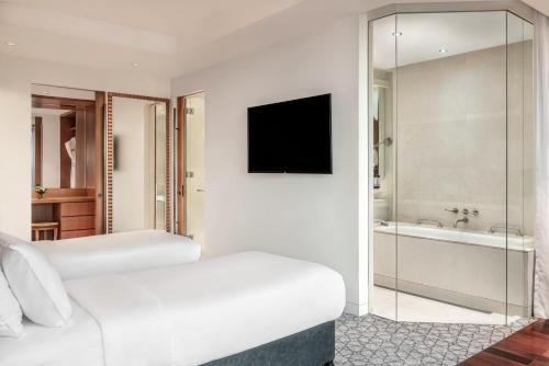 a hotel room with two beds and a television at The H Dubai in Dubai