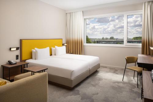 a hotel room with a bed and a window at Hyatt Place Paris Charles de Gaulle Airport in Roissy-en-France