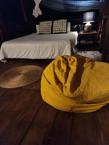 a bedroom with a bed with a yellow cover on the floor at Nagenahira Beach Villa in Nilaveli