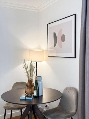 une table avec deux chaises et une table avec une lampe dans l'établissement 2 Pièces Parisien à Proximité de la Défense, à Puteaux