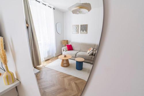a living room with a couch and a table at L Envolé - Jacuzzi - Proche Gare et Centre ville in Châlons-en-Champagne