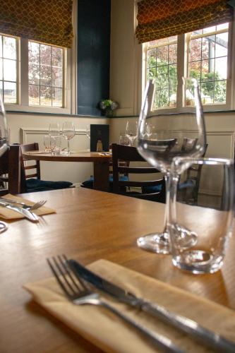 a table with wine glasses sitting on top of it at Rose & Crown Rooms in Beverley