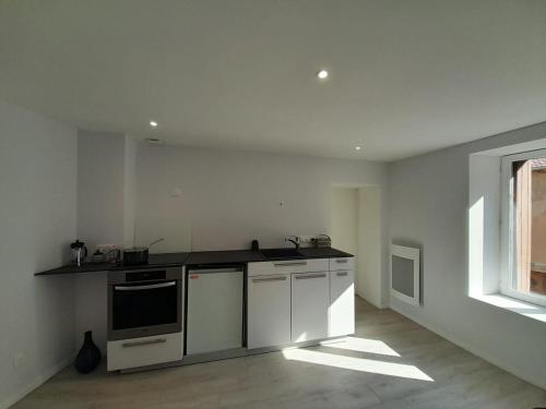 une cuisine avec des appareils électroménagers blancs et une fenêtre dans l'établissement Baccarat Tout Schuss !, à Baccarat