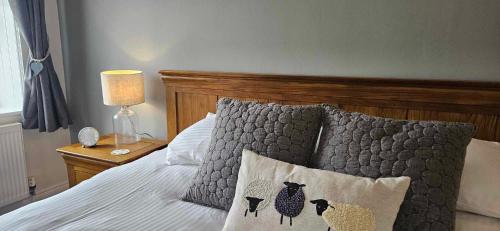a bed with three sheep pillows on it at Halmer Grange Guest House in Goathland