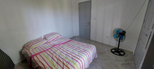 a bedroom with a striped bed and a fan at Maison de vacances vue sur la mer in Mazer