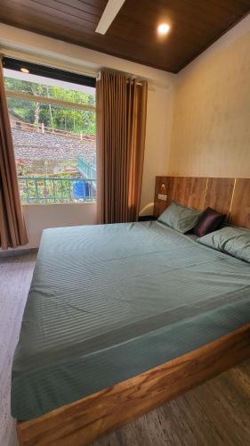 ein Schlafzimmer mit einem großen Bett mit einem großen Fenster in der Unterkunft Green Cradle in Munnar