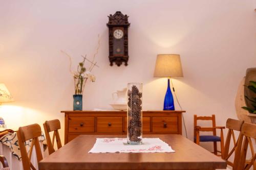 a dining room with a table with a clock on the wall at Can Olivera in Llubí