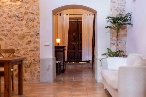 a hallway with a living room with a couch and a table at Can Olivera in Llubí