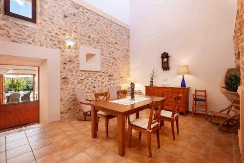 a dining room with a wooden table and chairs at Can Olivera in Llubí
