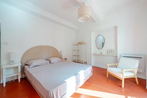 une chambre blanche avec un lit et une chaise dans l'établissement Charmant Appartement 2P au Cœur du Vieux Nice, à Nice