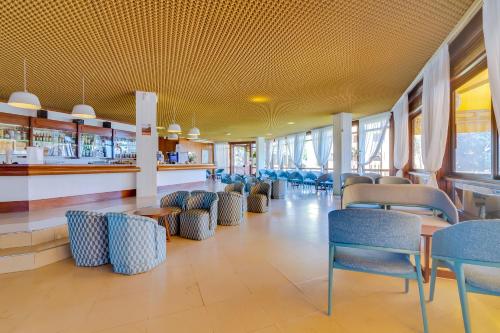 a restaurant with chairs and tables and a bar at Auramar Beach Resort in Albufeira