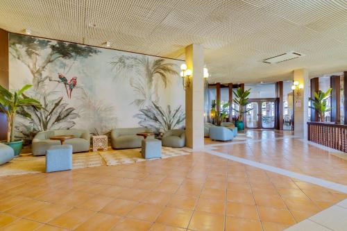 a lobby with a mural of plants on the wall at Auramar Beach Resort in Albufeira