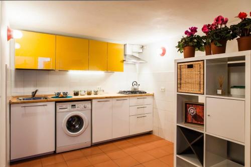 een keuken met gele kasten en een wasmachine en droger bij Cozy Apartment by the Vatican in Rome