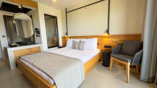 a bedroom with a bed and a chair and a mirror at Ayvalık Sea Long in Ayvalık