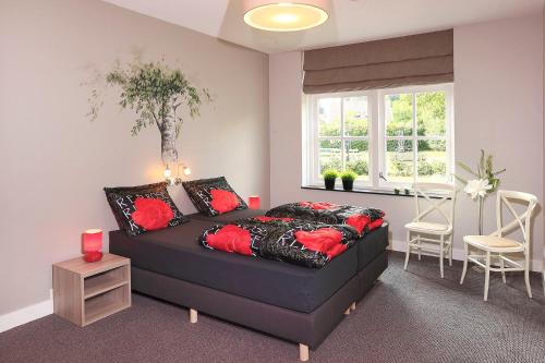 a bedroom with a black bed with red pillows at 't Borghuis in Losser