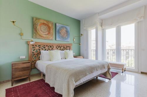 a bedroom with a large bed and two windows at Blueground La Dreta de lEixample elev washer BCN-150 in Barcelona