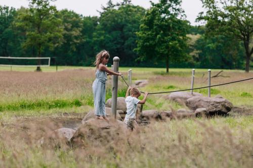 a woman and a child playing in a field at 't Borghuis in Losser