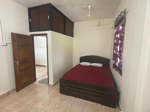 a small bedroom with a bed in a room at Rivera Homestay in Udupi