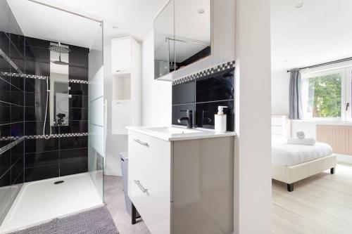 une salle de bain blanche avec une douche et un lavabo dans l'établissement L'Urban chic - proche des transports, à Villeneuve d'Ascq