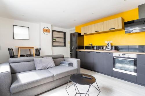 un salon avec un canapé et une cuisine dans l'établissement L'Urban chic - proche des transports, à Villeneuve d'Ascq