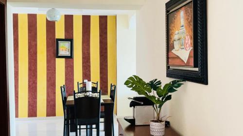 a dining room with a table with chairs and a painting at Appartement chic dans un complexe sécurisé à Malabata in Tangier