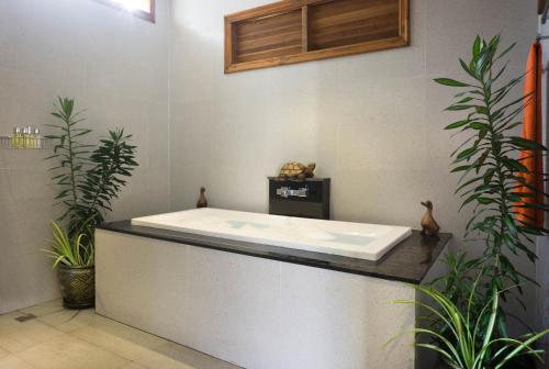 bañera en una habitación con plantas en Villa Topaz, en Laem Set Beach