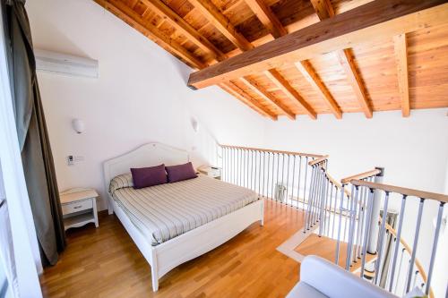 a room with a bed and a staircase with wooden ceilings at aCasaMia Wine Resort in San Cipriano Picentino