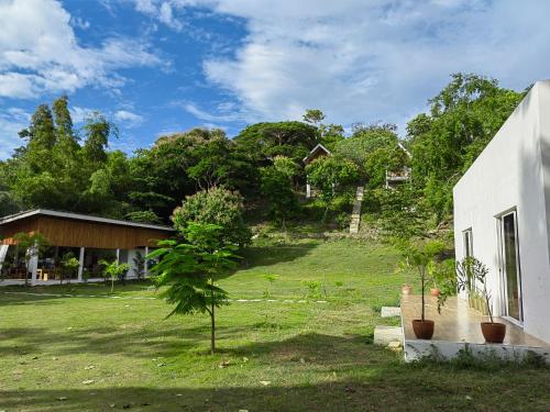a house with a green yard next to a building at MHARI Guest Rooms in San Juan