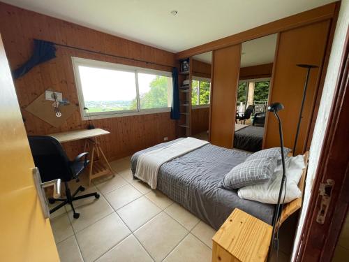 une chambre avec un lit, un bureau et une fenêtre dans l'établissement Indoor-Outdoor Villa with Panoramic Mountain Views Near Pyrenees Hikes & Atlantic Beaches, à Espoey