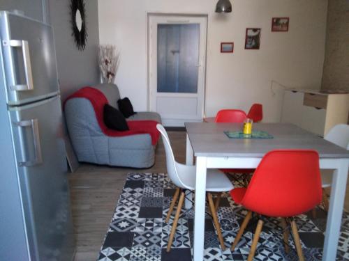 un salon avec une table et des chaises rouges dans l'établissement NAT-SEB 13 Avenue de Beaulieu, à Marennes