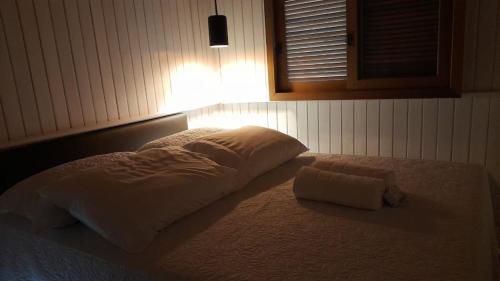 a white bed with a pillow and a towel on it at Pousada Luar dos Campos in Bom Jardim da Serra