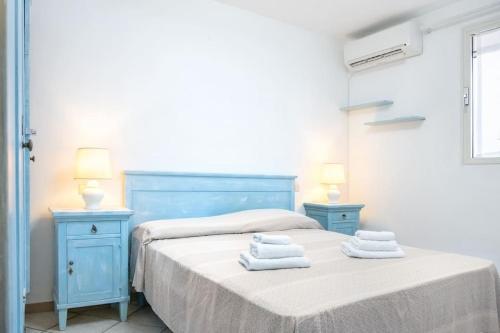 a bedroom with two beds and two blue night stands at Villa Costa Smeralda Golfo di Marinella AC e WiFi in Golfo Aranci