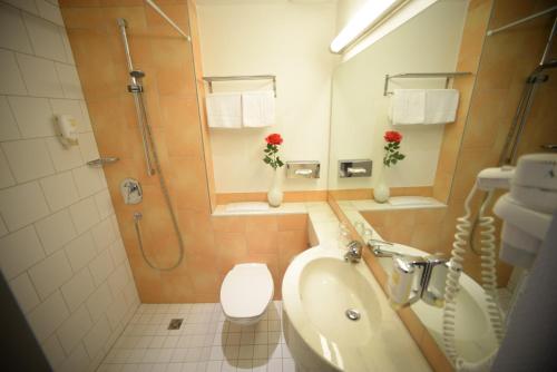a bathroom with a sink and a toilet and a shower at L'Escala in Dreieich