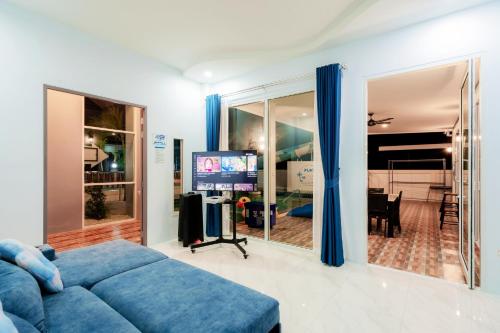 a living room with a blue couch and a tv at พลอยพูลวิลล่า ชะอำ 4 Ploy Poolvilla Cha-am 4 in Cha Am