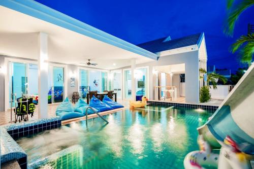 a swimming pool with a slide in a villa at พลอยพูลวิลล่า ชะอำ 4 Ploy Poolvilla Cha-am 4 in Cha Am