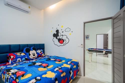 a bedroom with a blue bed with cartoon characters on it at พลอยพูลวิลล่า ชะอำ 4 Ploy Poolvilla Cha-am 4 in Cha Am