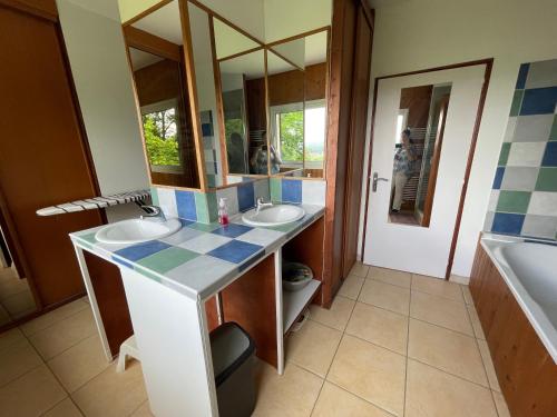 une salle de bain avec deux lavabos et un miroir dans l'établissement Indoor-Outdoor Villa with Panoramic Mountain Views Near Pyrenees Hikes & Atlantic Beaches, à Espoey