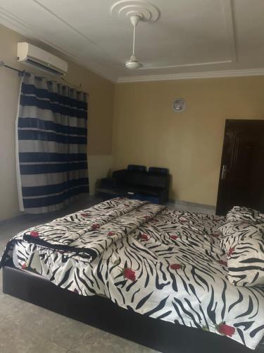 a bedroom with a bed with a zebra print sheets at Avina specious room in Lomé