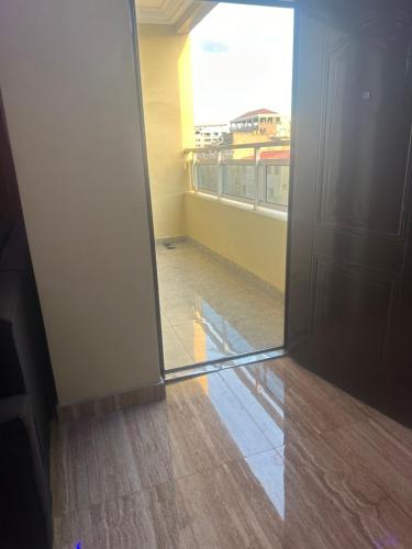an open door to an empty room with a window at Avina specious room in Lomé