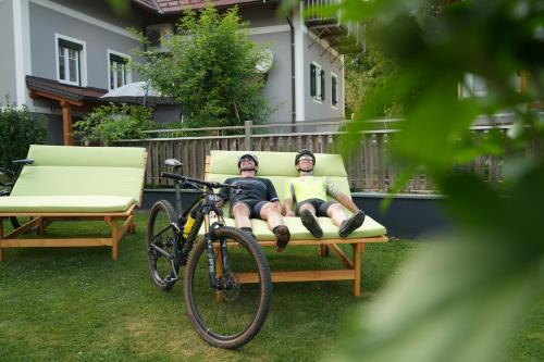 two people sitting on a bench next to a bike at Mühlbauerhof in Großklein