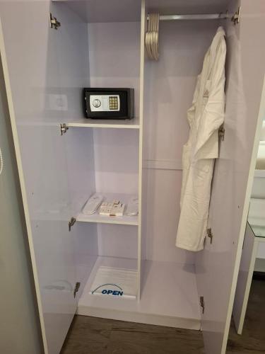 a white closet with a clock on a shelf at درة دارين للشقق المخدومة اقتصادي Dora darin for servieced apartments economic in Al Bukayriyah