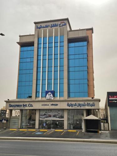 a large building with blue windows on a street at Farah Hotel Apartments in Jeddah